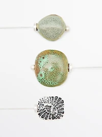 Brooch with textured ceramic piece and medallion