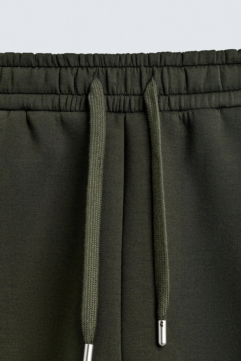 NEOPRENE EFFECT PLEATED LONG BERMUDA SHORTS
