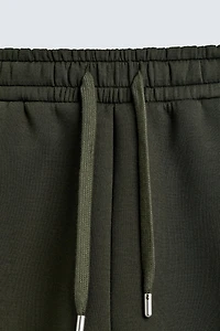 NEOPRENE EFFECT PLEATED LONG BERMUDA SHORTS