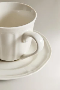 PORCELAIN TEACUP WITH SAUCER AND RAISED DESIGN
