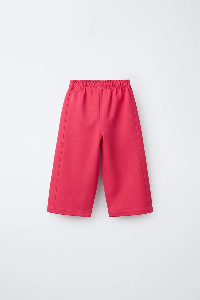 WIDE LEG INTERLOCK RAISED TEXT PANTS