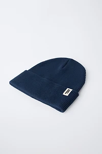 BONNET EN MAILLE CANNELÉE À ÉTIQUETTE