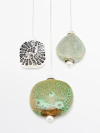 Brooch with textured ceramic piece and medallion