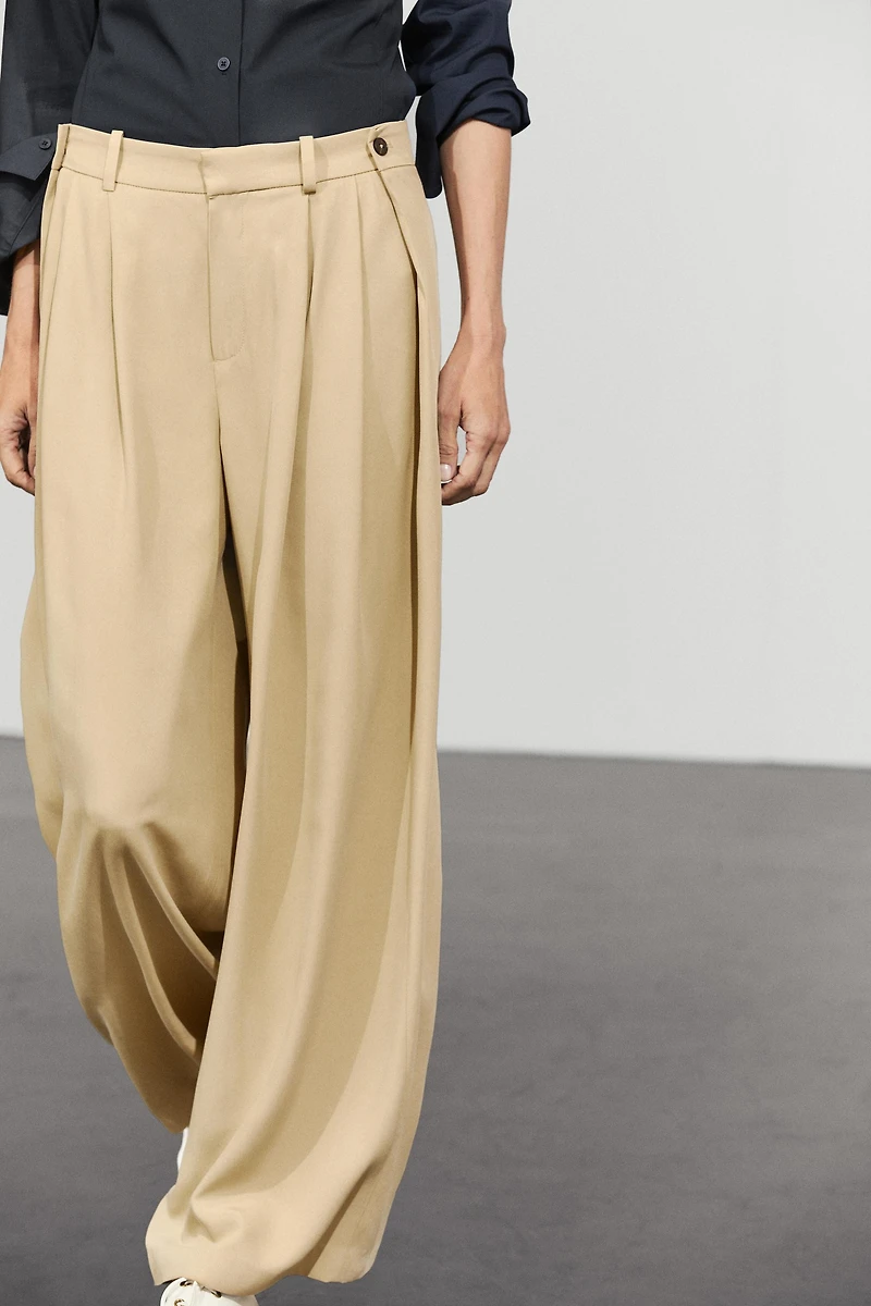 Flowing pleated pants with button detail
