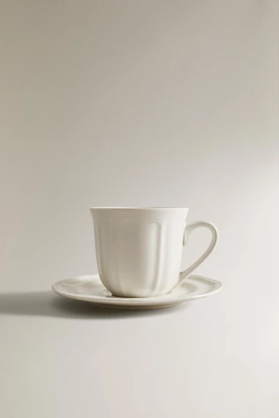 PORCELAIN TEACUP WITH SAUCER AND RAISED DESIGN