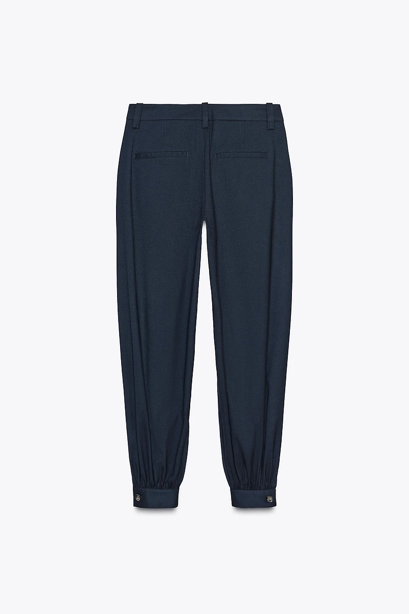 PLEATED PANTS WITH BUTTONED HEM