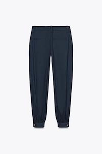 PLEATED PANTS WITH BUTTONED HEM