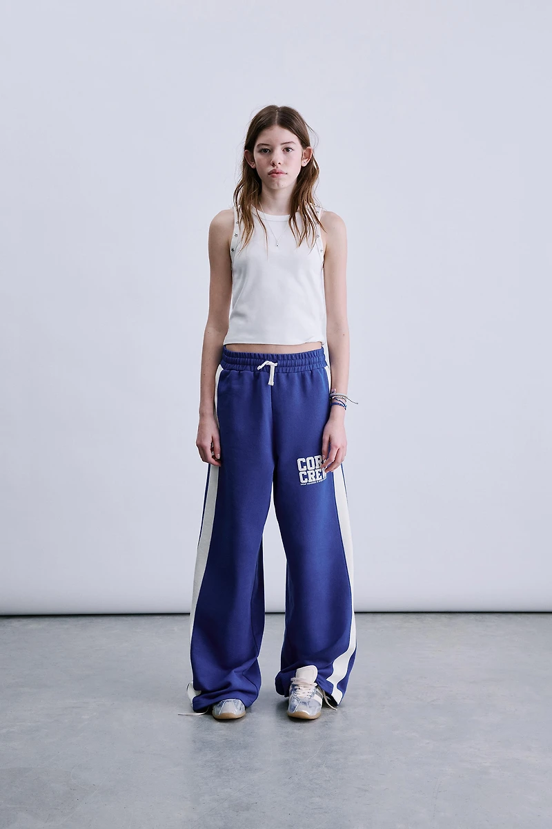 PANTALON À JAMBES LARGES ET BANDES SUR LES CÔTÉS