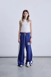 PANTALON À JAMBES LARGES ET BANDES SUR LES CÔTÉS