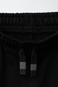 PANTALON EN MATIÈRES VARIÉES AVEC ÉTIQUETTE