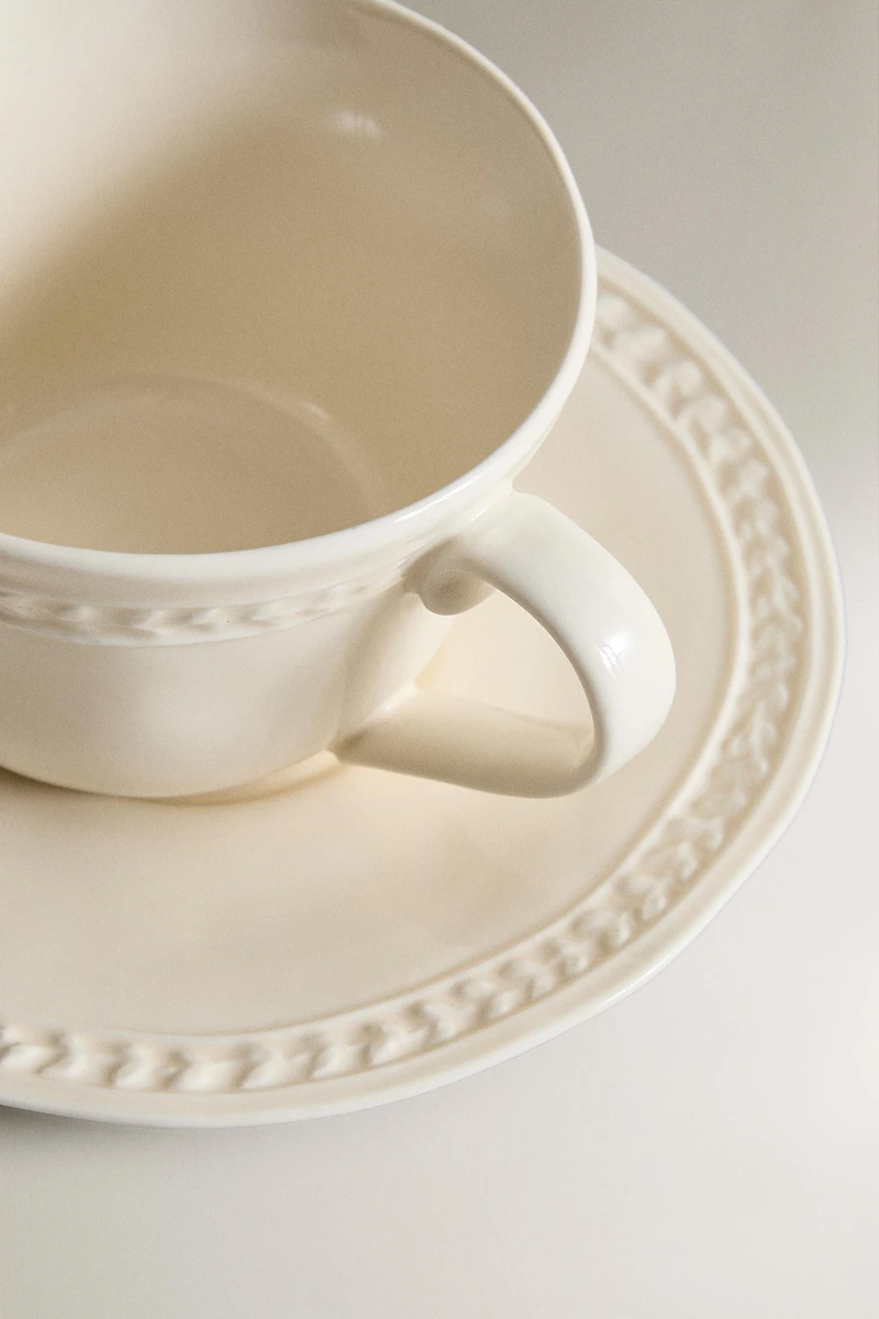 RAISED STONEWARE TEACUP AND SAUCER