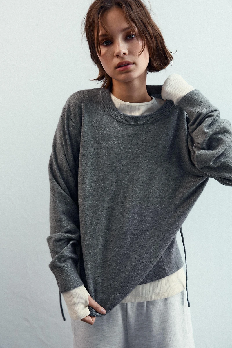 PULL EN MAILLE AVEC OUVERTURE ET CORDONS AU DOS