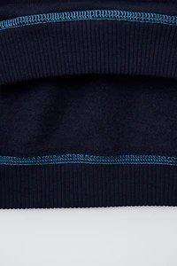 SWEAT À INSCRIPTION ET SURPIQÛRES EN CONTRASTE