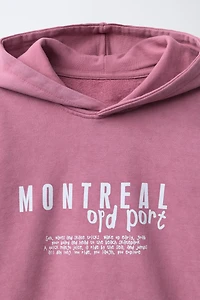SWEAT À CAPUCHE ET INSCRIPTION