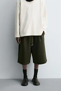 NEOPRENE EFFECT PLEATED LONG BERMUDA SHORTS