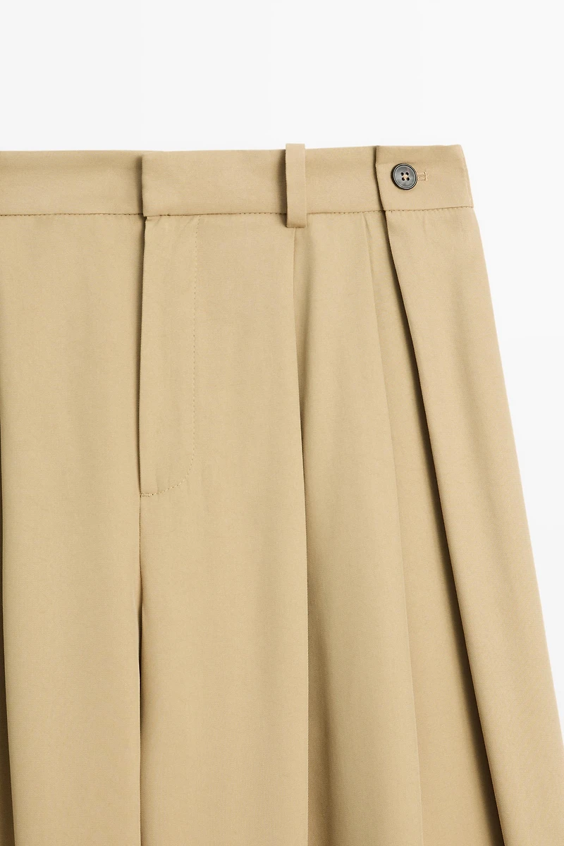 Flowing pleated pants with button detail