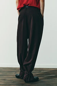 PLEATED PANTS WITH BUTTON HEM