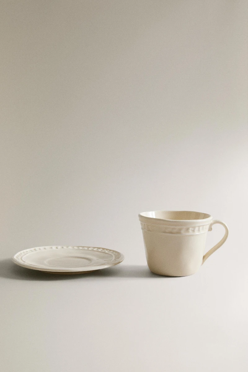 STONEWARE RAISED DESIGN COFFEE CUP AND SAUCER