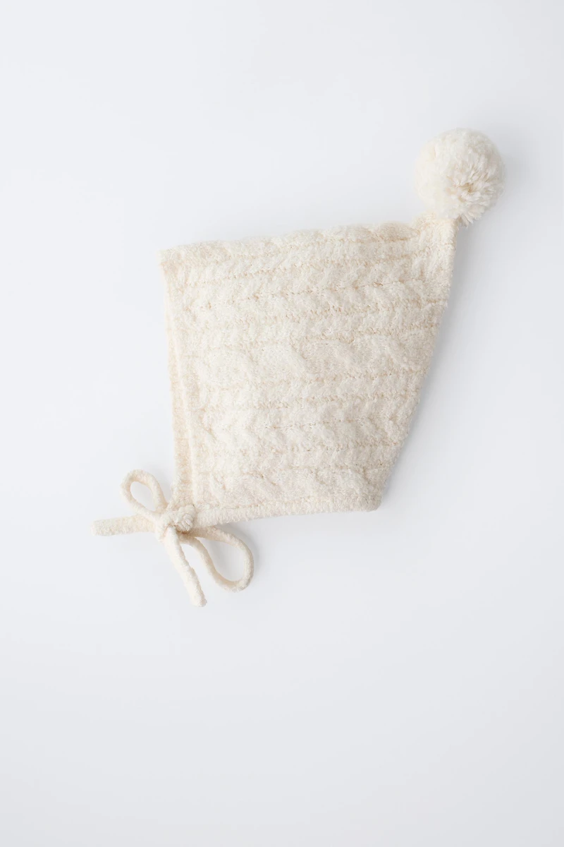 BONNET EN MAILLE À TORSADES ET POMPON