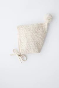 BONNET EN MAILLE À TORSADES ET POMPON