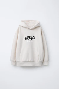 SWEAT À CAPUCHE AVEC INSCRIPTION BRODÉE