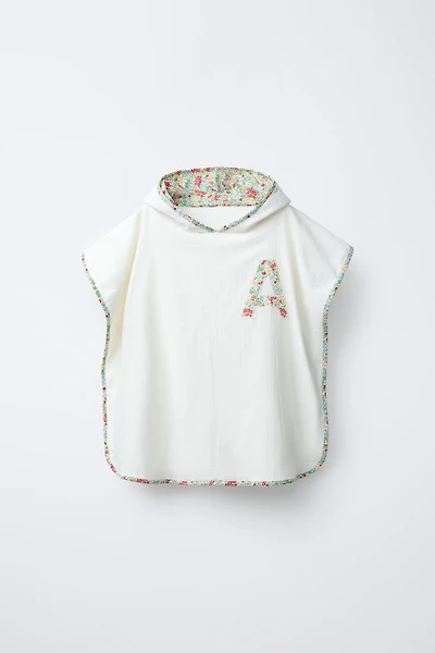 TEXTURED TOWEL PONCHO WITH FLORAL TRIM