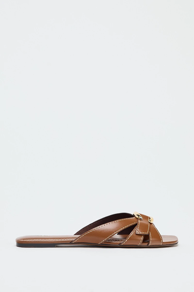 CROSSED SANDALS WITH METALLIC DETAIL