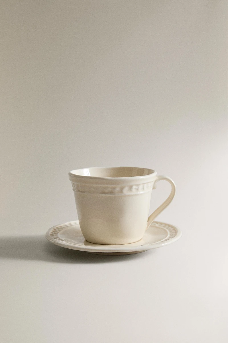 STONEWARE RAISED DESIGN COFFEE CUP AND SAUCER
