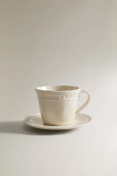 STONEWARE RAISED DESIGN COFFEE CUP AND SAUCER