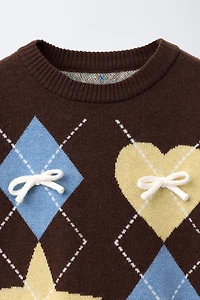 PULL EN MAILLE À LOSANGES ET NŒUDS