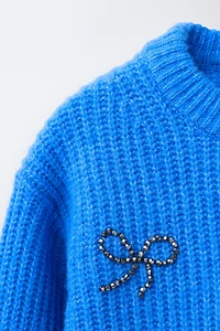 PULL EN MAILLE AVEC ORNEMENTS FANTAISIE LACETS BRILLANTS