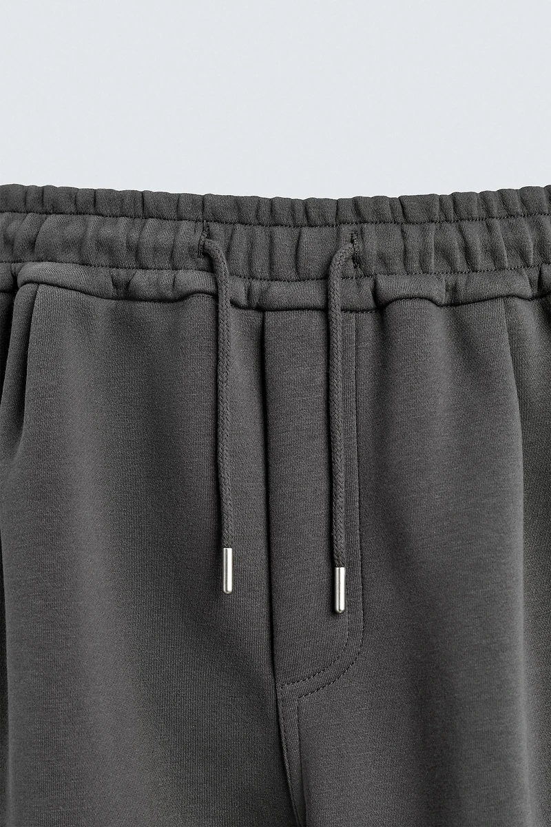 NEOPRENE EFFECT CARGO PANTS WITH PLEATS