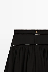 Flowing trousers with contrast detail