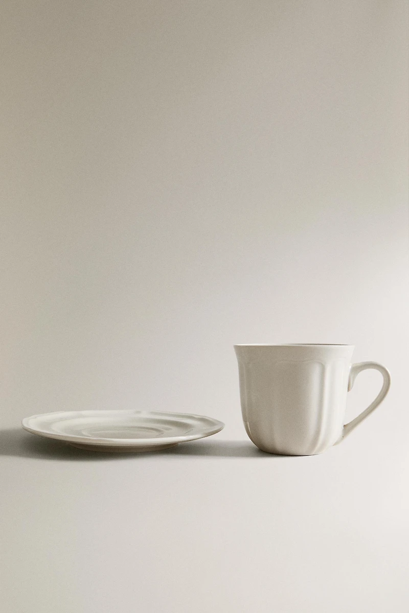 PORCELAIN TEACUP WITH SAUCER AND RAISED DESIGN