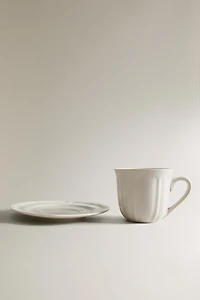 PORCELAIN TEACUP WITH SAUCER AND RAISED DESIGN