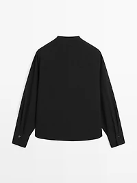 Blouse with crossover detail and button