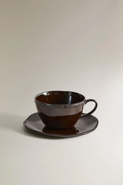 STONEWARE COFFEE CUP AND SAUCER WITH RAISED DESIGN