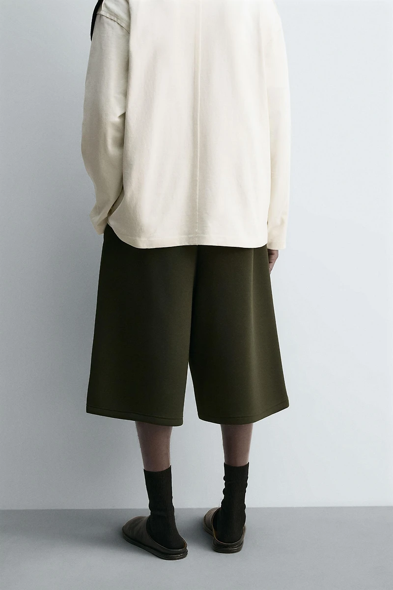 NEOPRENE EFFECT PLEATED LONG BERMUDA SHORTS
