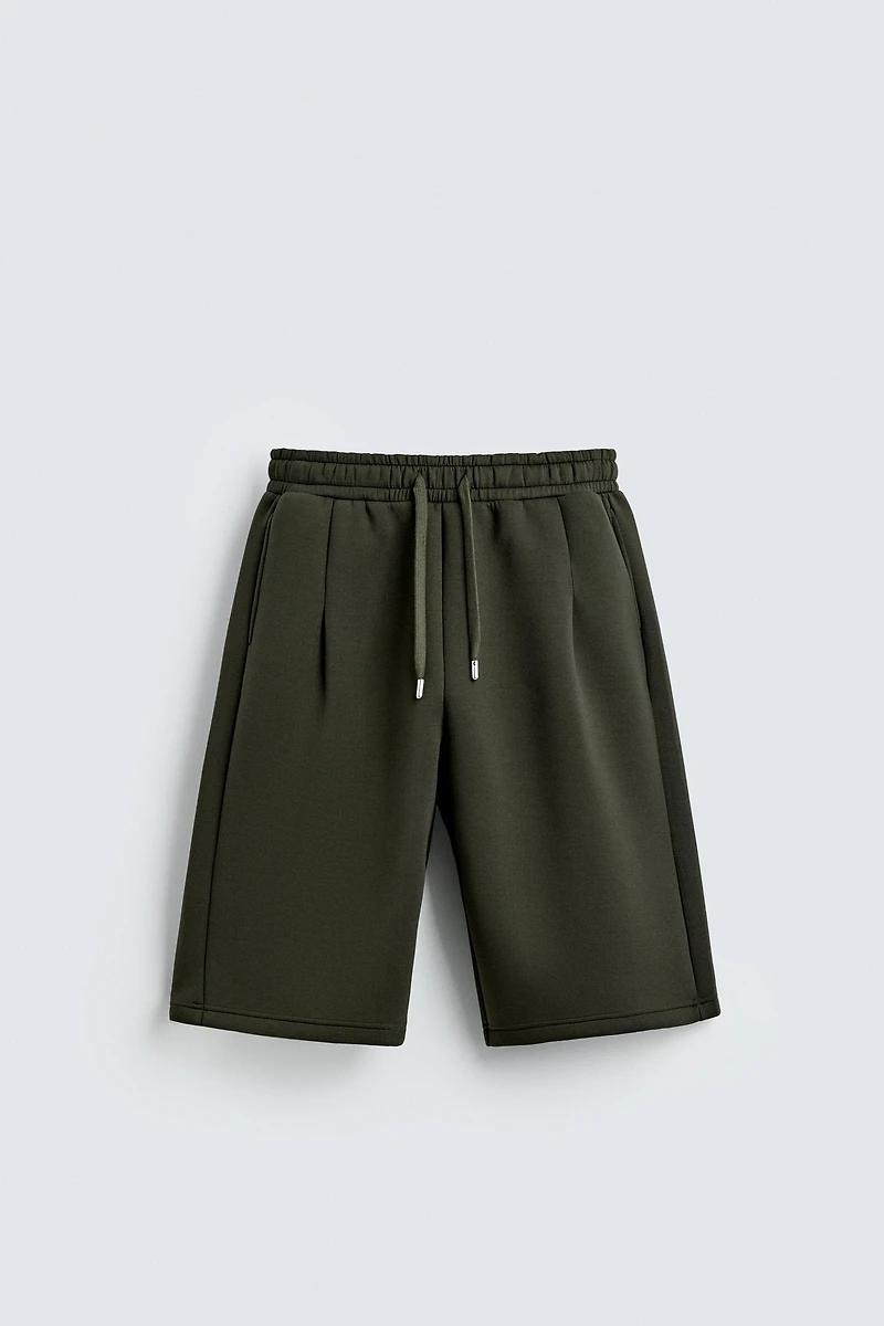 NEOPRENE EFFECT PLEATED LONG BERMUDA SHORTS