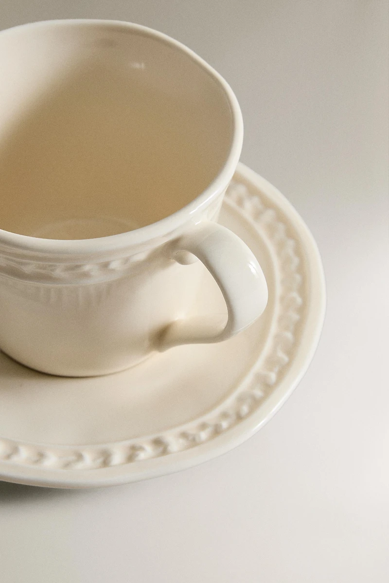 STONEWARE RAISED DESIGN COFFEE CUP AND SAUCER