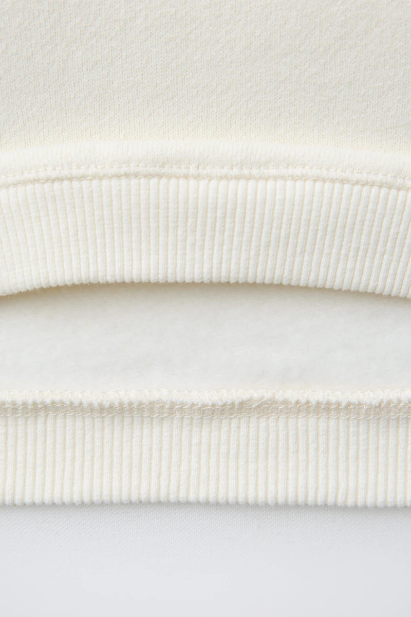 SWEAT AVEC PIÈCE VELOURS BOUCLÉ SNOOPY PEANUTS™