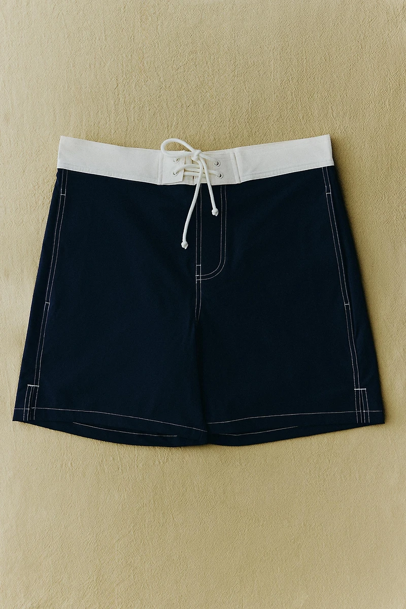 SHORT DE BAIN MI-LONG À COUTURES