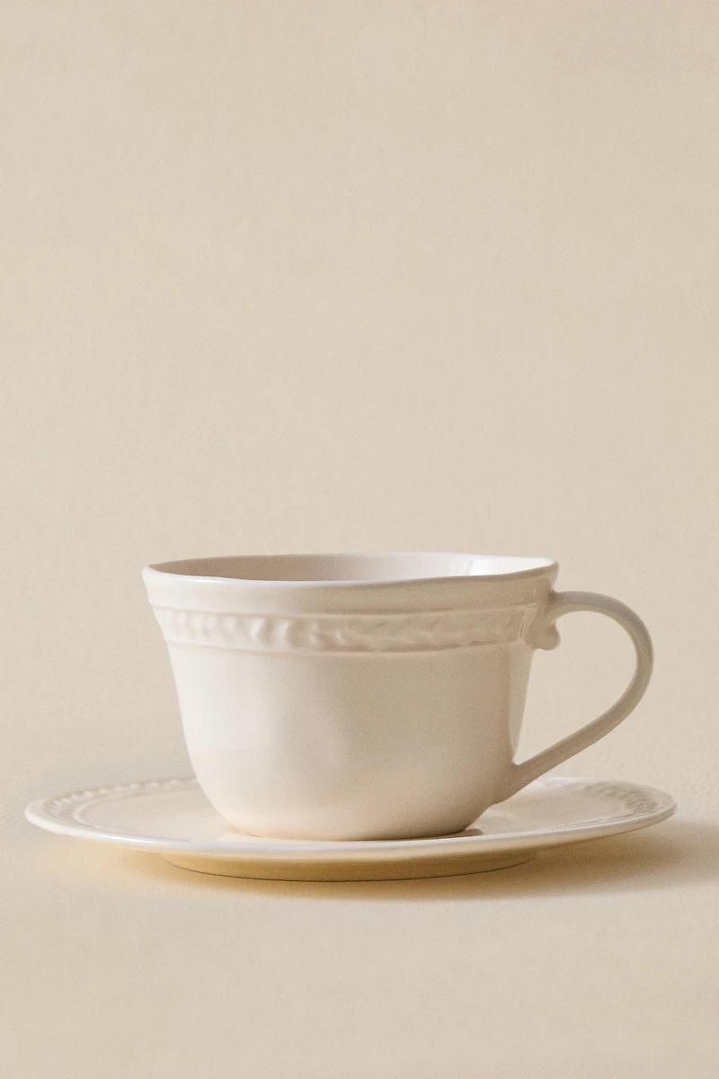 RAISED STONEWARE TEACUP AND SAUCER