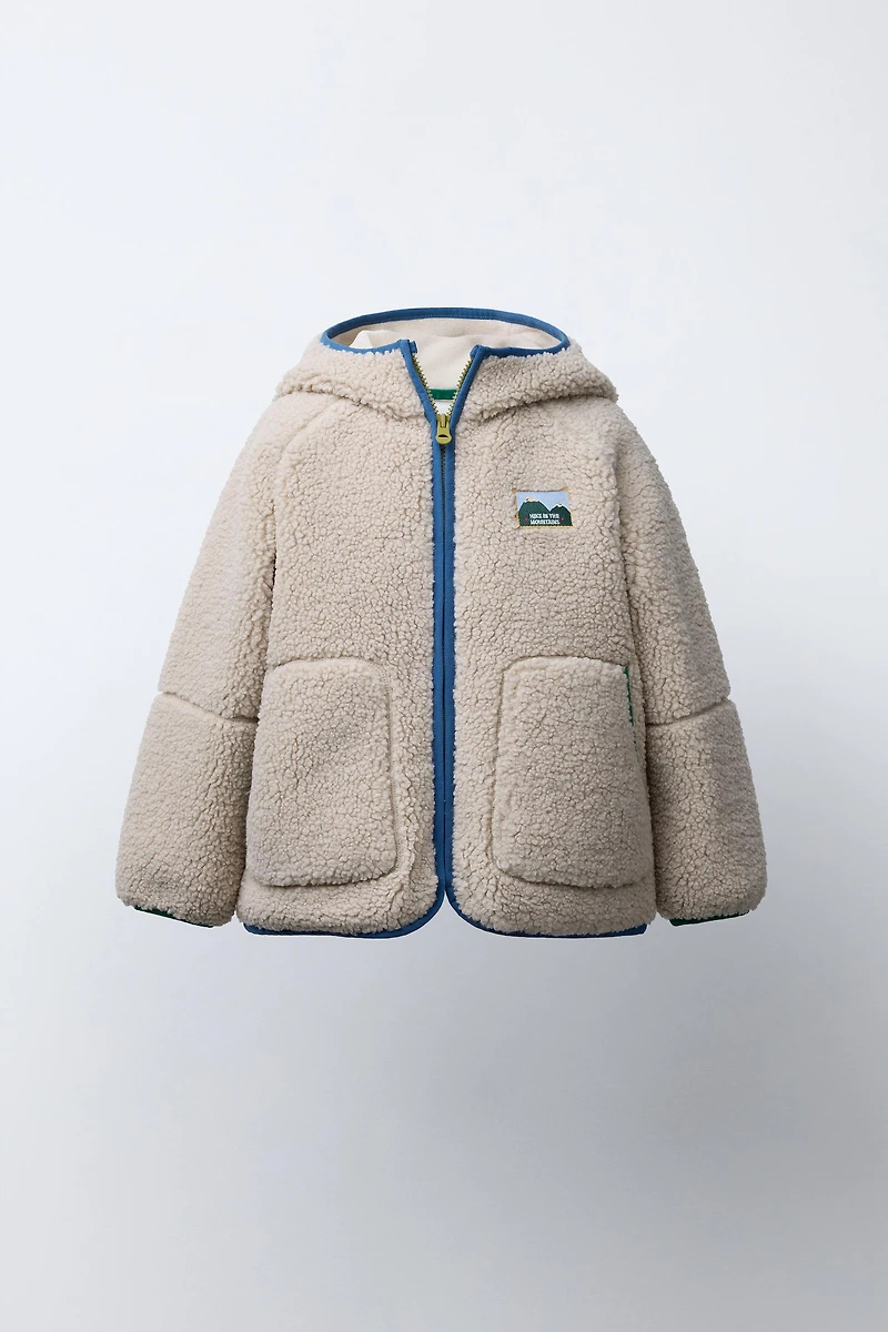 VESTE EFFET MOUTON CAPUCHE LISERÉS CONTRASTE