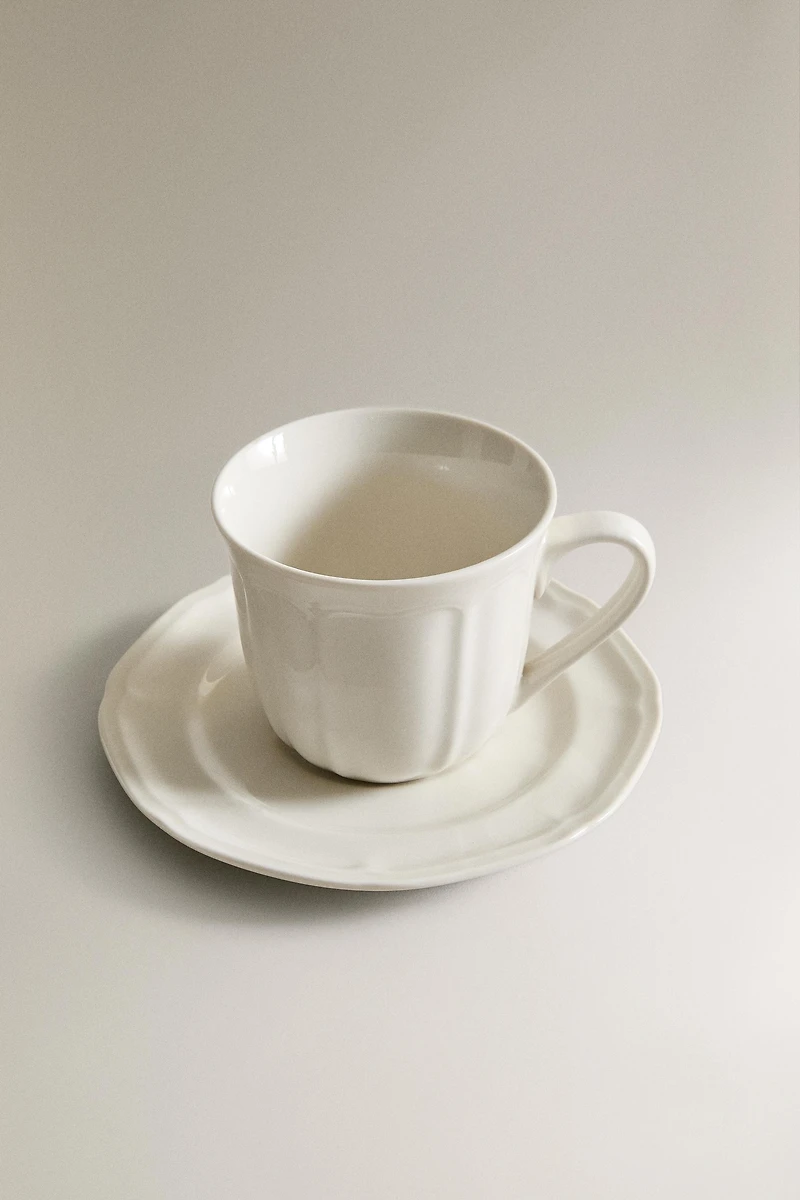 PORCELAIN TEACUP WITH SAUCER AND RAISED DESIGN