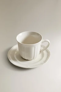 PORCELAIN TEACUP WITH SAUCER AND RAISED DESIGN