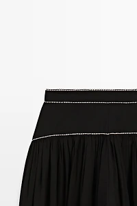 Flowing trousers with contrast detail