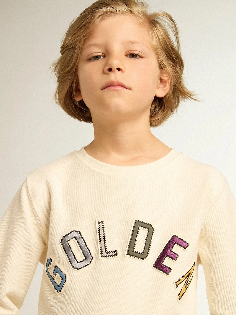 Sweatshirt aged white with multicolor Golden lettering on the front