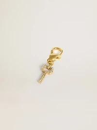 Key-shaped charm in gold-colored brass with crystals