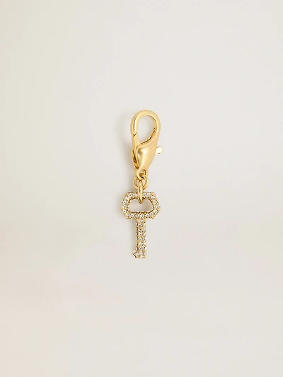 Key-shaped charm in gold-colored brass with crystals